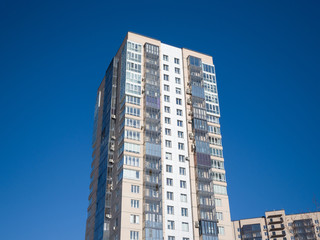 New residential building on a background of blue sky. Theme of modern geometric architecture and urbanization