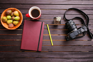 Photographers journal and his camera on a wooden table 