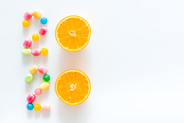 Sweet New Year design. 2020 laid out with candy and oranges on white background top view copy space