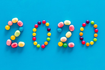 Sweet New Year design. 2020 laid out with candy on blue background top view copy space