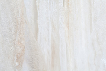 Obraz premium Hanging grungy gauze fabric against white cloth background in shallow depth of field with subtle shadows light and shapes as blurred texture and design element as part of Halloween themed images