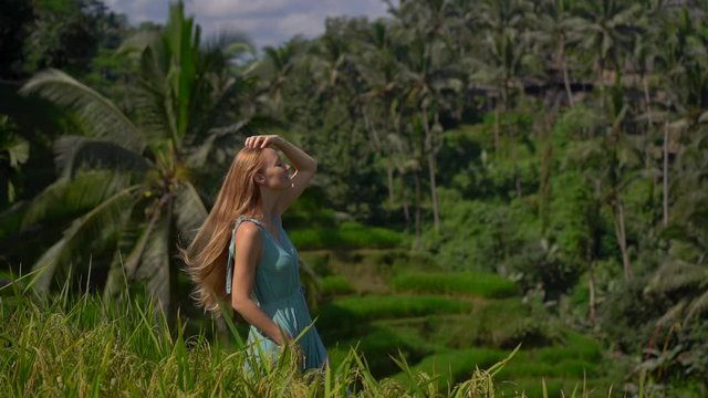 Slowmotion shot of a beautiful young woman in a blue dress visits famous Tegalalang Rice Terraces in Ubud village on the Bali island