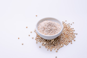 Uncooked raw Sorghum flour (also known as sorgo) in a white bowl, isolated on white background