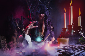 Female witch sitting at a table casting spell.