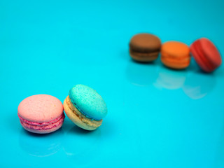 Colorful french macarons (macaroons) cake,  delicious sweet dessert on blue background with copyspace, food background concept.