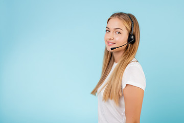 friendly smiling blonde call center operator with headset isolated over blue