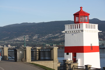 red and white lighthouse by the bridge