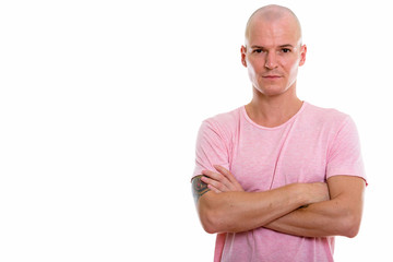 Studio shot of young handsome bald man with arms crossed