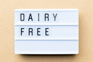 White lightbox with word dairy free on wood background