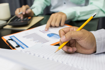 Business man Writing expense information in home office.team work concept