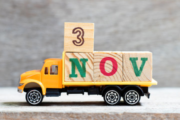Truck hold letter block in word 3nov on wood background (Concept for date 3 month November)