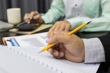 Business man Writing expense information in home office.team work concept
