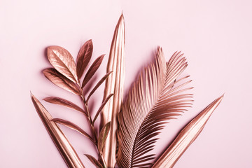 Painted in pink metallic tropical leaves on pink pastel background. Natural Creative layout