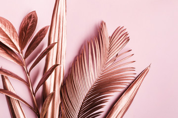 Natural Creative layout made of Painted pink metallic leaves on pink pastel background