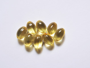 Fish fat in capsule on light background.