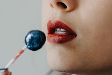 woman's mouth with a lollipop in her hands