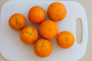 Fresh citrus oranges on the white cutting board