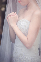 Close-up of a bride under a veil pray for blessings from god the marriage the symbol of love