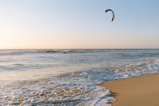 Man kitesurfing at Scarborough Beach as the sun sets over the ocean in the distance. 