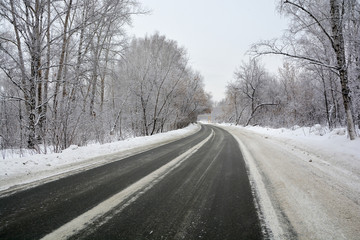 Fototapeta na wymiar Snowy winter road in pine and birch forest.The Northern part of Russia