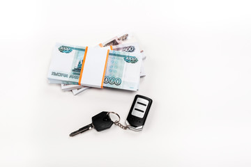 top view of car key with key chain near stacks of russian money on white