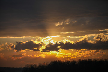 Sunrise behind clouds with reflection off upper layers
