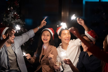 Group of diversity people having great Christmas party in working office together at night. They...