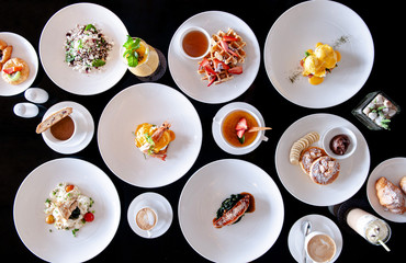 Many European breakfast dishes  and coffee on black table top view