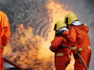 Naklejka premium firefighter spray water to fire burning car workshop fire training
