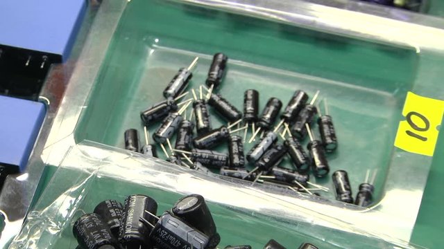 New electrolytic capacitors are in plastic containers. Electronic components packaged for mass production. 