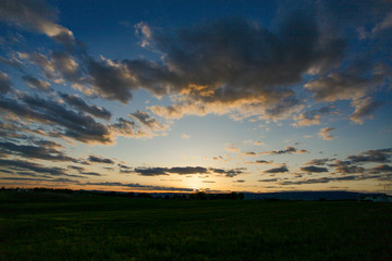 Fototapeta na wymiar Sunrise and clouds over field