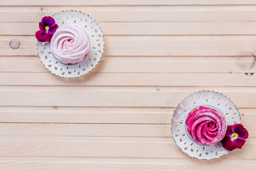 Colorful zephyr on wooden background.Set of homemade white and pink zephyr or marshmallow on wooden background. Marshmallow, Meringue, Zephyr, pansy.Tasty meringues.Copy space