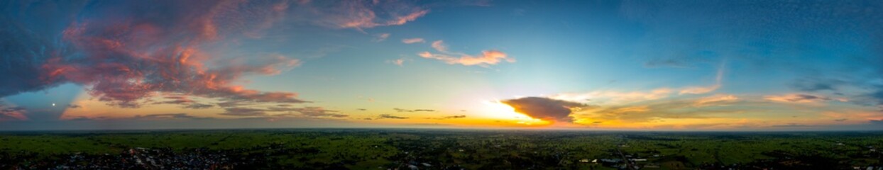 Panorama Top view Aerial photo from flying drone over village in Thailand.Top view beautiful Sunset.Sunrise with cloud over rice field.