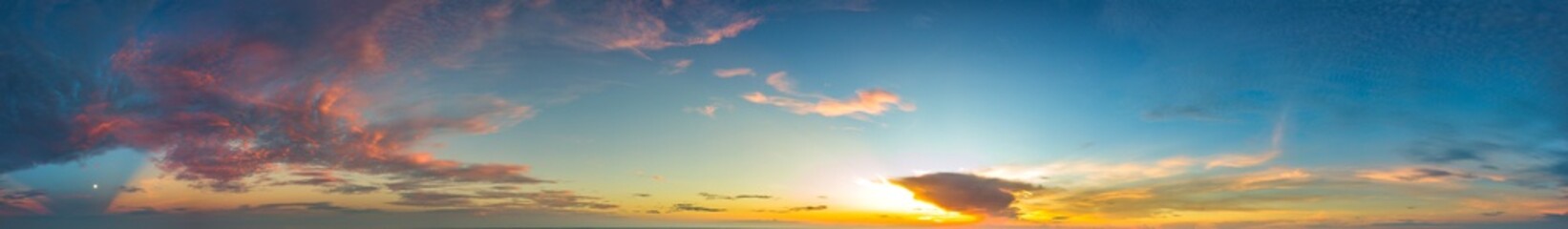 Panorama Sunlight with dramatic sky. Cumulus sunset clouds with sun setting down on dark background.Vivid orange cloud sky.