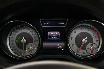 View to the black interior of car with dashboard, speedometer, tachometer,odometer and red arrows...