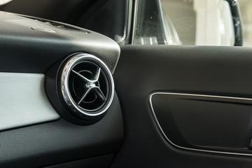 View to the black interior of car with dashboard, ventilation ducts, door and chrome after cleaning before sale on parking