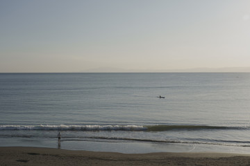 Paddle surfer and  a man screaming on the beach