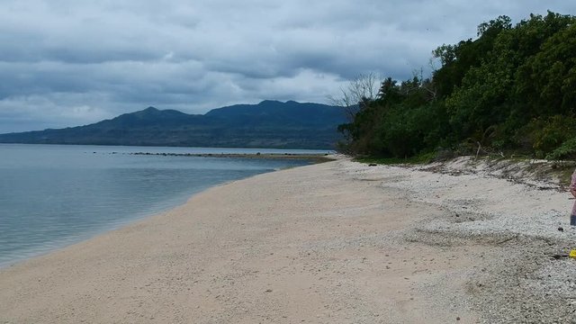 A girl walking along a deserted tropical island in the Pacific Ocean region