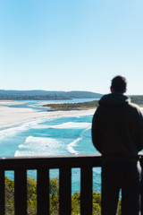 Ocean Beach, Denmark, Australia. Beautiful wide beach with surfers surfing waves in clear blue water. River mouth can be seen in the background with some trees in the foreground.