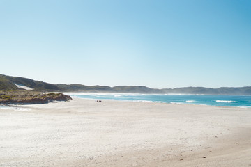 Beautiful white sand secluded, large beach in Albany with mountains as the background over the crisp blue ocean water.
