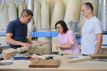 Industrial woodworking workshop, team of people discussing carpentry process