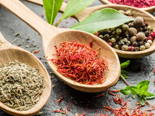 Assortment of colorful spices in the wooden spoons.