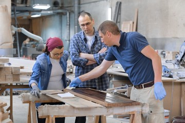 Group of people working in carpentry workshop