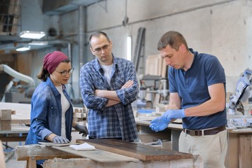 Group of people working in carpentry workshop