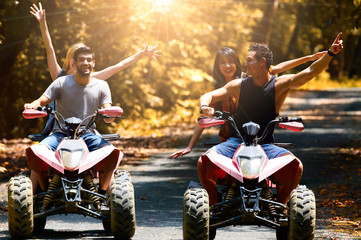 Two pairs of young lovers drive ATV tour in the fall.
