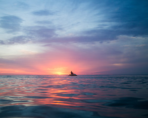 Sunset over ocean with jetski