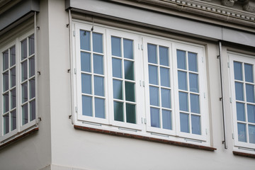 Reflecting  windows of a white house consist of small glass panes