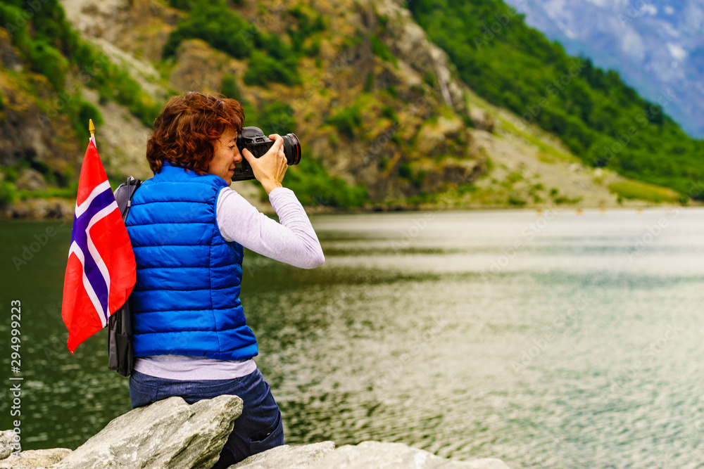 Wall mural tourist with camera on fjord, norway