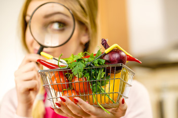 Woman investigating shopping backet with vegetables