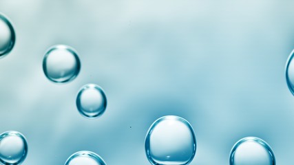 transparent gas bubbles on water surface. Worms-eye low angle with crystal bubbles in purified water on blue background. cosmetic background with copy space